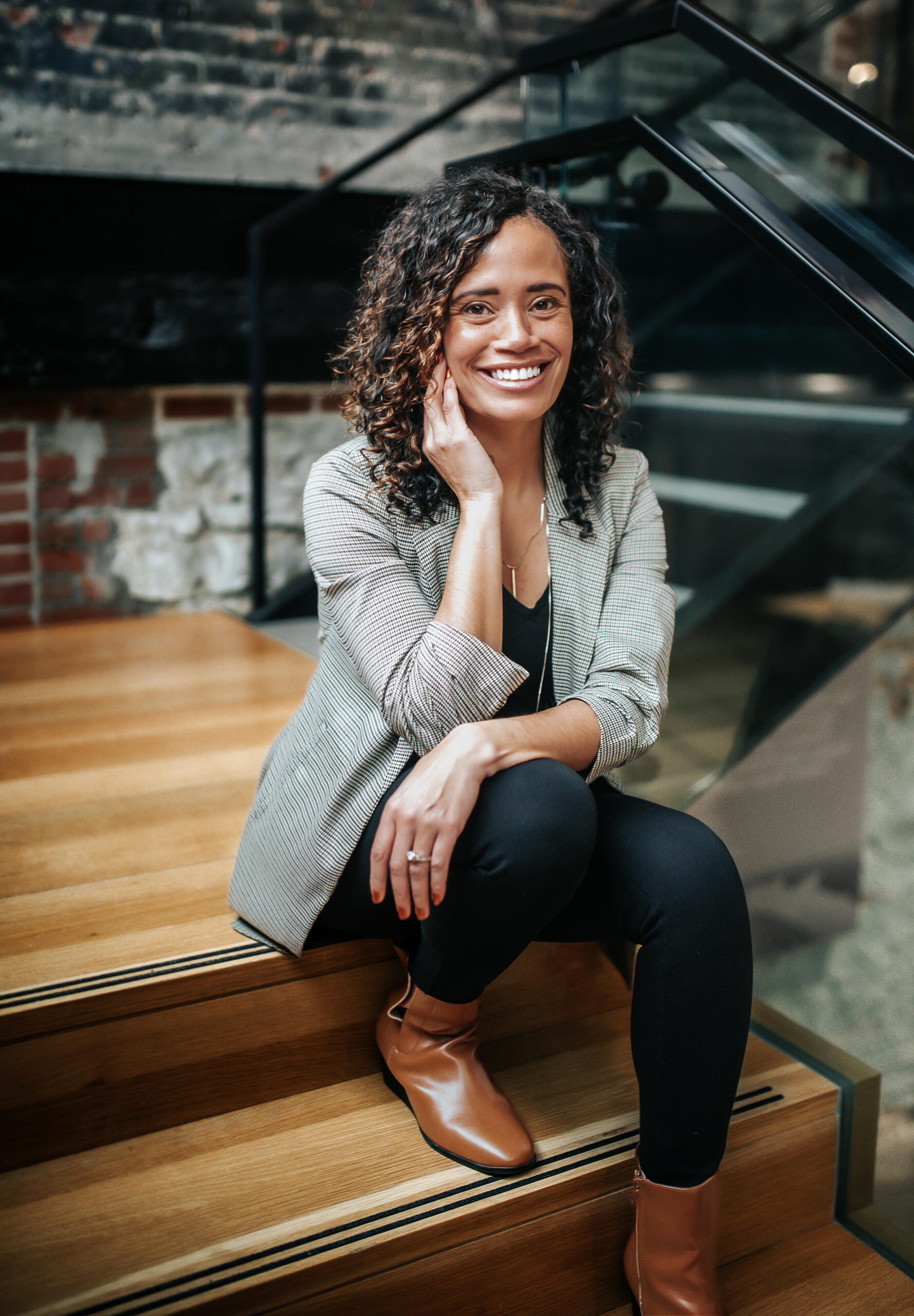 Photo of Amanda, smiling with arms crossed, and standing in front of a bookshelf